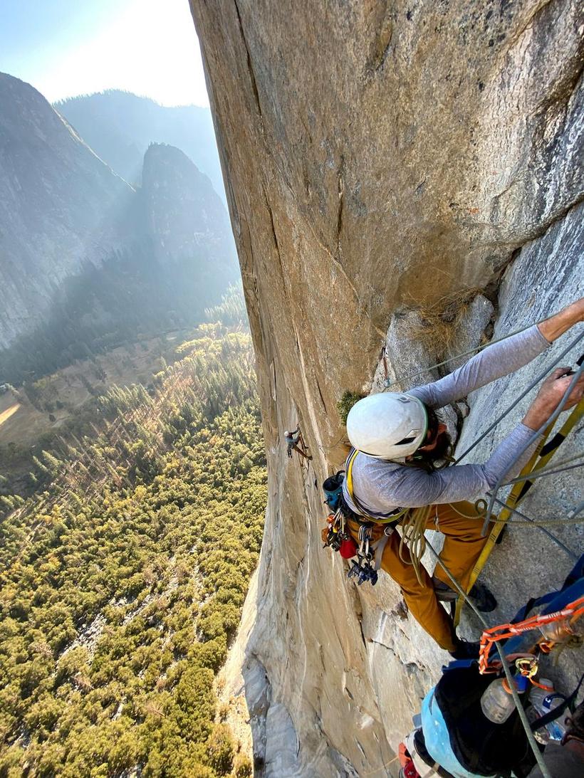 A climber leading a big wall pitch high above the valley