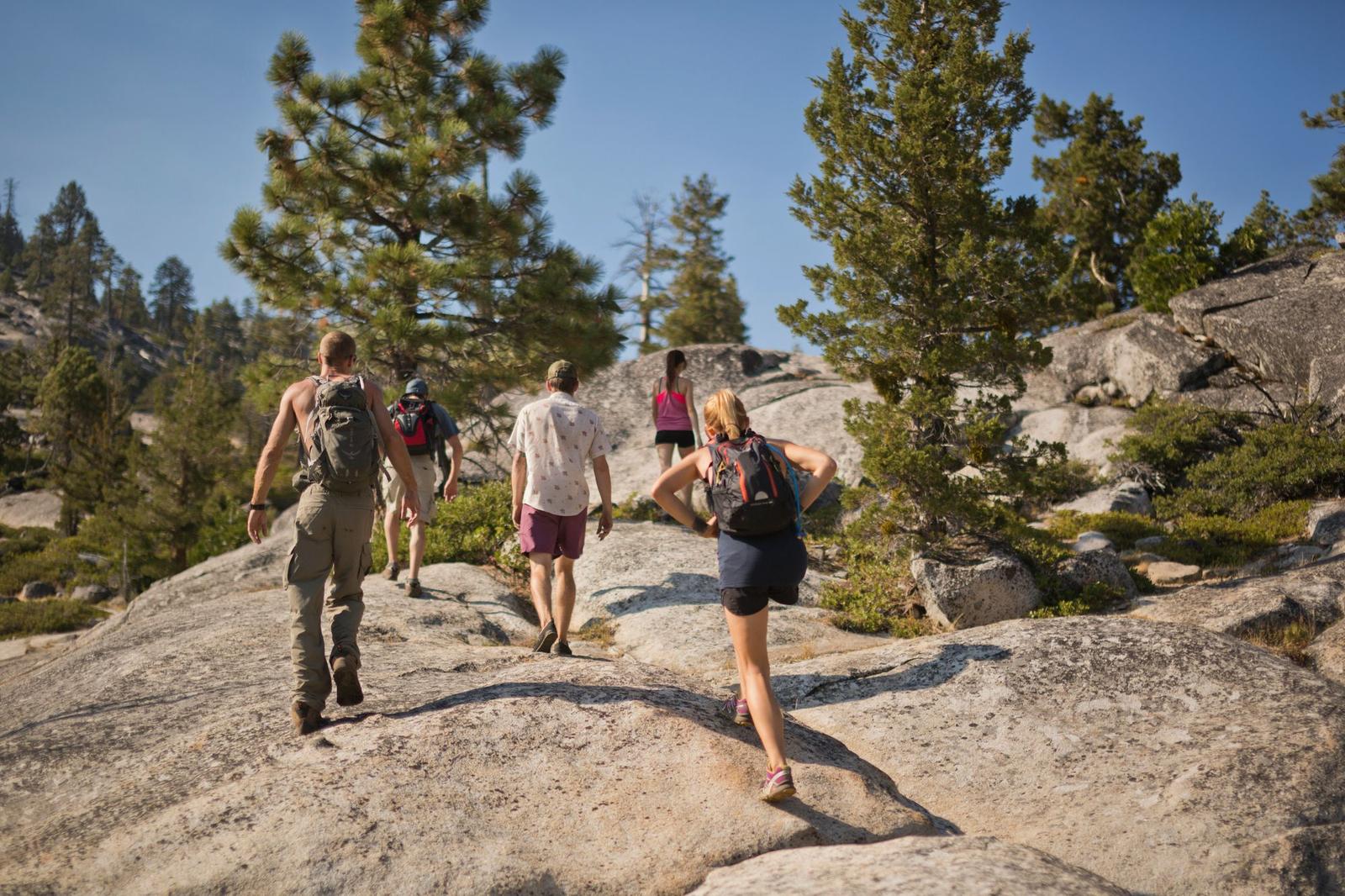 Friends hiking together across granite slabs