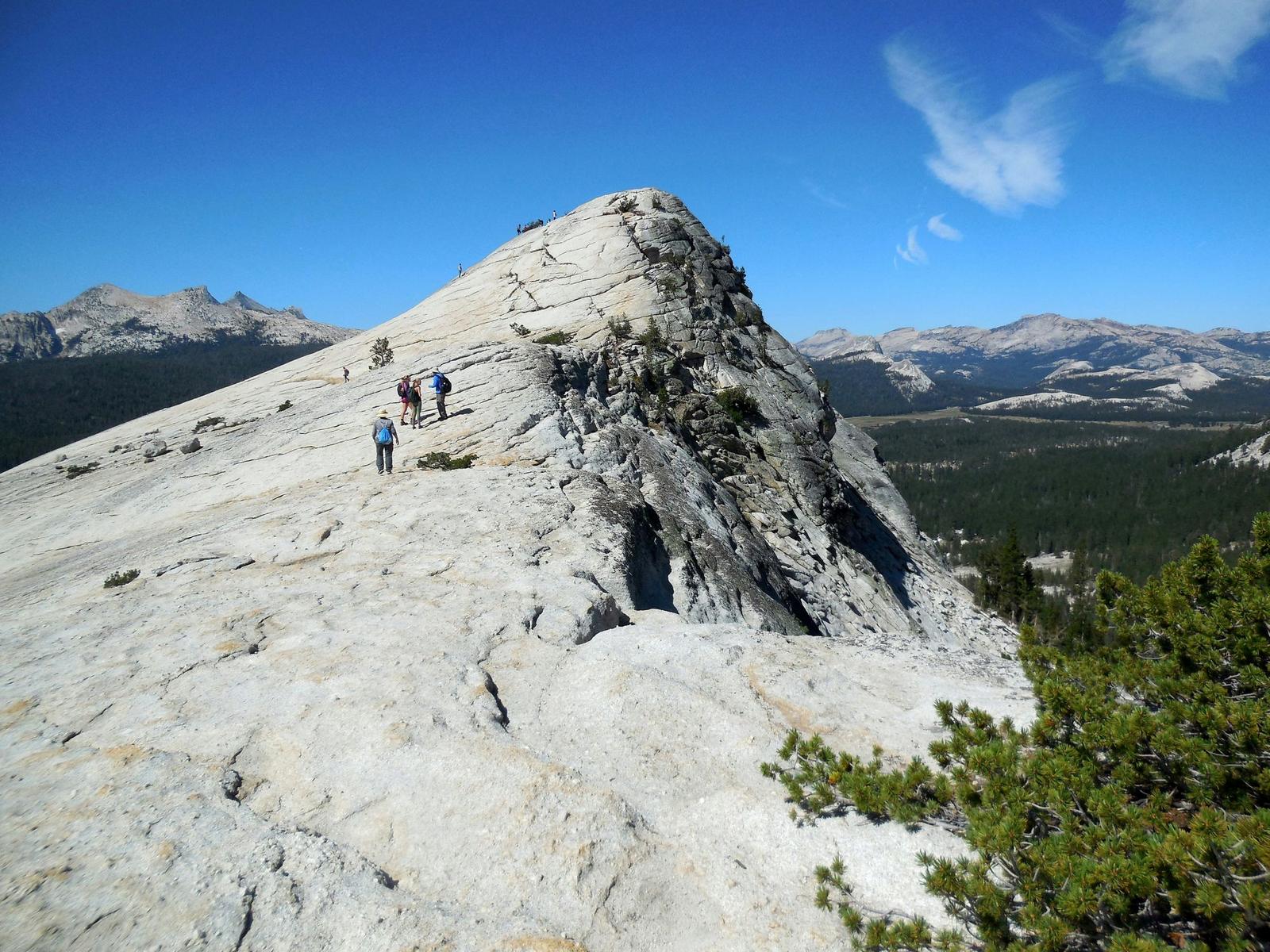 Hikers on the summit ridge of a granite dome